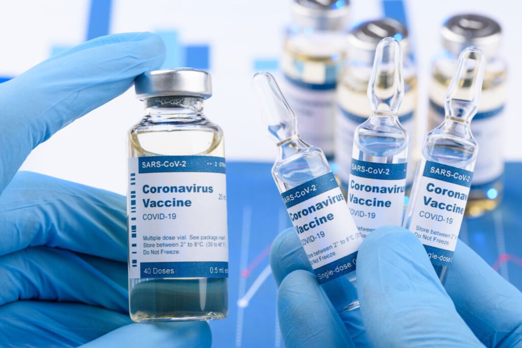 Closeup of vials of the COVID vaccine being held