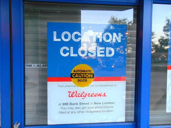 Door of pharmacy with "Location Closed" sign