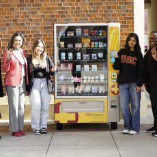 Staff members and students pose in front of the newly-installed pharmacy vending machine at USC Village.
