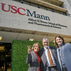 USC President Carol L. Folt, Dean Vassilios Papadopoulos and USC Trustee Chair Suzanne Nora Johnson, from left, pause in front of the building sporting the school’s new name. (USC Photo/Gus Ruelas)